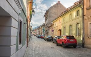 a street with cars parked on the side of a building at Antler Boutique in Braşov