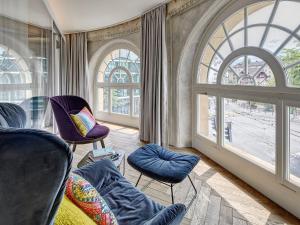 uma sala de estar com cadeiras e uma grande janela em Hotel Anker Luzern em Lucerna