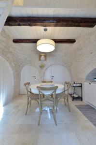 uma sala de jantar com uma mesa branca e cadeiras em Suite Curcuma em Alberobello