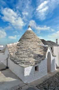 a building with a stone roof with a sky at Suite Curcuma in Alberobello