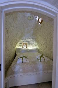 a small bedroom with a bed in a stone wall at Suite Curcuma in Alberobello