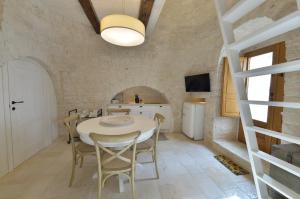 uma cozinha e sala de jantar com mesa e cadeiras em Suite Curcuma em Alberobello