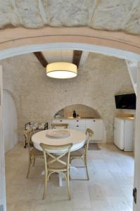 cocina y comedor con mesa y sillas en Suite Curcuma en Alberobello