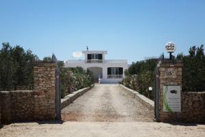 een oprit naar een wit huis met een poort bij Villa Giulia & Gaia - Guest House in Nardò