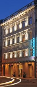 a lit up building with a street in front of it at Atrium Fashion Hotel in Budapest