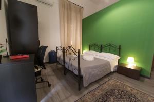 カターニアにあるTra L'Etna E Il Mare B&Bの緑の壁のベッドルーム1室