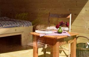 a wooden table with a vase of flowers on it at Mountain view Glamping in Dovje