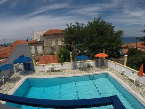 basen z leżakami i parasolami obok budynku w obiekcie Apartments Zafiria w mieście Ágios Konstantínos