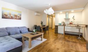 a living room with a couch and a table at Violetos Lux Apartamentai in Druskininkai