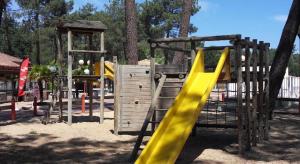 ein Spielplatz mit einer gelben Rutsche in einem Park in der Unterkunft CHALET 407 KHELUS-CLUB in Gujan-Mestras