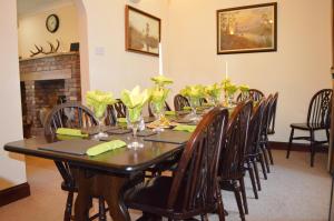 una mesa de comedor con sillas y flores. en Culzean House, en Ardentinny