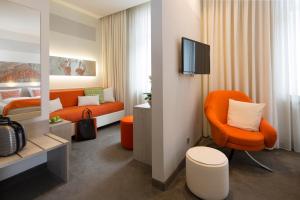 a hotel room with an orange chair and a bed at Hotel am Markt in Baden-Baden