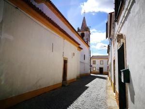 an empty alley with a building and a church at Casa do Peso in Vale do Peso