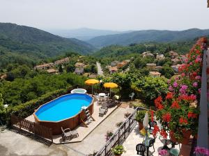 a resort with a swimming pool and mountains in the background at Amelia Hotel in Momigno