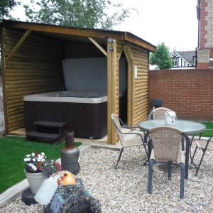 a backyard patio with a table and a hot tub at Little Parklands Apt2 in Sandown