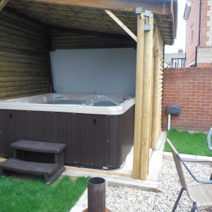 a hot tub in a backyard with a wooden structure at Little Parklands Apt2 in Sandown