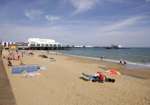 a group of people on a beach near the ocean at Little Parklands Apt2 in Sandown