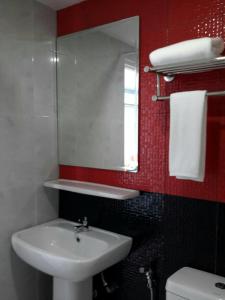 une salle de bain avec un lavabo et un miroir et des toilettes dans l'établissement Sakura Budget Hotel, à Hat Yai 29 autres photos