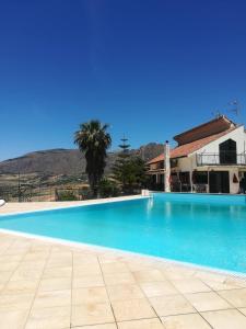 a large blue swimming pool in front of a house at Kairos B&B in San Giuseppe Jato