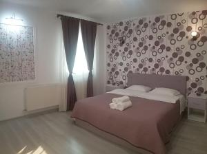 Apartament Liliac في بوخارست: غرفة نوم بسرير كبير مع بطانية بنية اللون