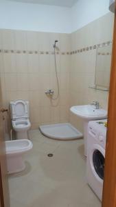 a bathroom with a toilet a sink and a washing machine at Residenca Juli in Vlorë +93 photos