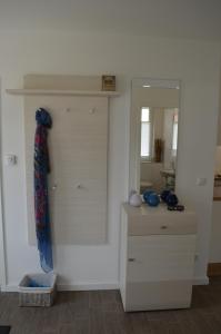 a white room with a dresser and a mirror at Ferienhaus Vier Jahreszeiten in Glowe