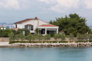 a house on the shore of a body of water at Beach apartment M & B in Poljana