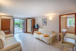 a living room with a couch and a tv at Beach apartment M & B in Poljana