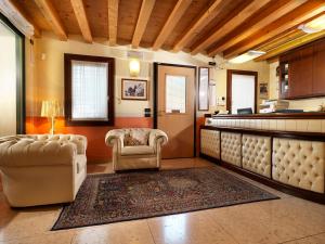 a large room with a bar with two chairs at Hotel & Residence Roma in Camposampiero