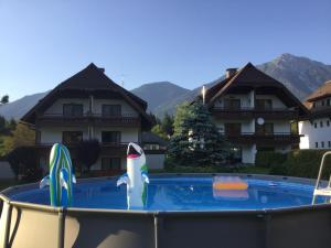 una piscina frente a una casa con un fideo en el medio en Ferienhaus Andrä en Hermagor