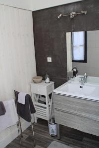een badkamer met een wastafel, een bad en een spiegel bij Une Chambre en Ville in Saintes