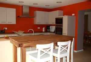 een keuken met een houten tafel en witte stoelen bij Les Haies in Solwaster