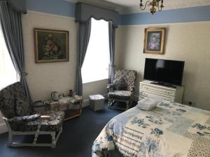 um quarto com uma cama e uma televisão de ecrã plano em Tanamara Guest House em Retford