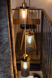 a group of three lights hanging from a set of stairs at L'Orangeraie et la Palmeraie d'Endoume in Marseille