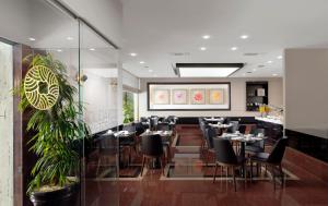 a restaurant with tables and chairs in a room at Holiday Suites in Athens