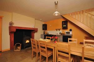a dining room with a table and a fireplace at Les Chambres d'Eponine in Saints-Geosmes