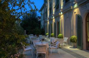 une rangée de tables et de chaises à l'extérieur d'un bâtiment dans l'établissement Hotel Ercolini & Savi, à Montecatini Terme