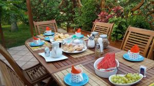 a wooden table with plates of food and fruit on it at Il Giardino delle Jacaranda in Talsano