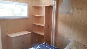 ein Schlafzimmer mit Holzwänden und Regalen sowie einem Fenster in der Unterkunft CHALET 407 KHELUS-CLUB in Gujan-Mestras + 21 Fotos