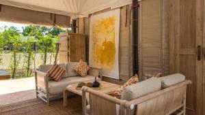 a porch with a couch and a table at Khwan Beach Resort - Luxury Glamping and Pool Villas Samui - Adults Only - SHA Extra Plus in Mae Nam