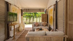 a living room with a couch and a table at Khwan Beach Resort - Luxury Glamping and Pool Villas Samui - Adults Only - SHA Extra Plus in Mae Nam
