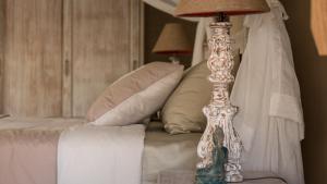 a bedroom with a bed with a lamp on a table at Khwan Beach Resort - Luxury Glamping and Pool Villas Samui - Adults Only - SHA Extra Plus in Mae Nam