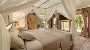 a bedroom with a large bed with white curtains at Khwan Beach Resort - Luxury Glamping and Pool Villas Samui - Adults Only - SHA Extra Plus in Mae Nam