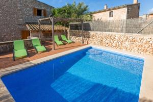 a pool with chairs and a house at Casa Rural Sa Sorda in Campos