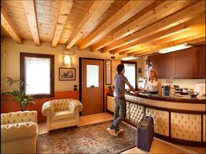 a man and a woman standing at a kitchen counter at Hotel & Residence Roma in Camposampiero