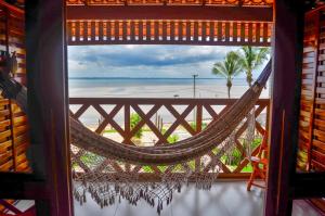 a hammock in a room with a view of the beach at Pousada Jagatá in Tutóia