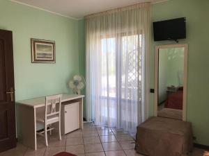 a room with a desk and a bed and a window at Agriturismo Il Crinale in Castorano