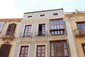 マラガにあるApartamento "Casa del Árbol"の窓とバルコニー付きの建物の外観