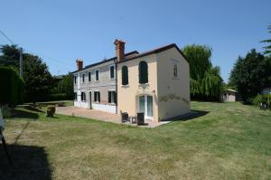 a large white house with a grass yard at antiche distillerie "buon dormire" in Pincara