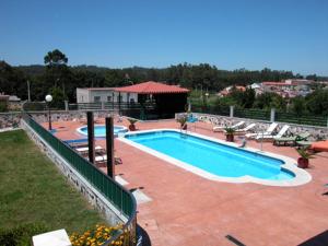 a large swimming pool with lounge chairs at Pension Asun Sanxenxo in Sanxenxo +21 photos